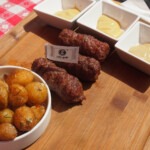 Mititei (Mici) Romanian Skinless Sausages mititei served for lunch with fried baby potatoes and a selection or Romanian mustards